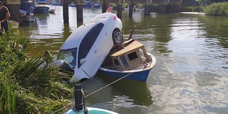 Otomobil, nehir kenarındaki teknenin üzerine düştü